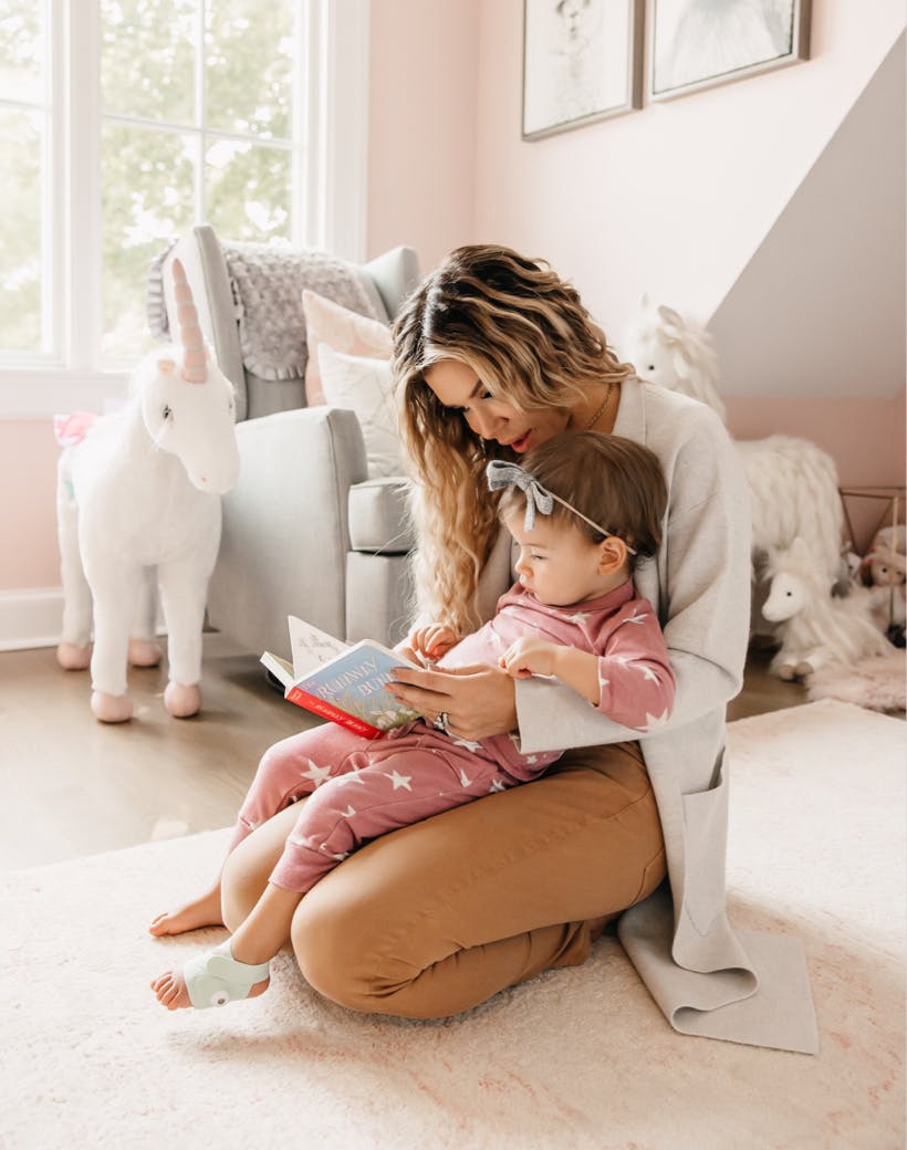 Mom reading to toddler in her lap